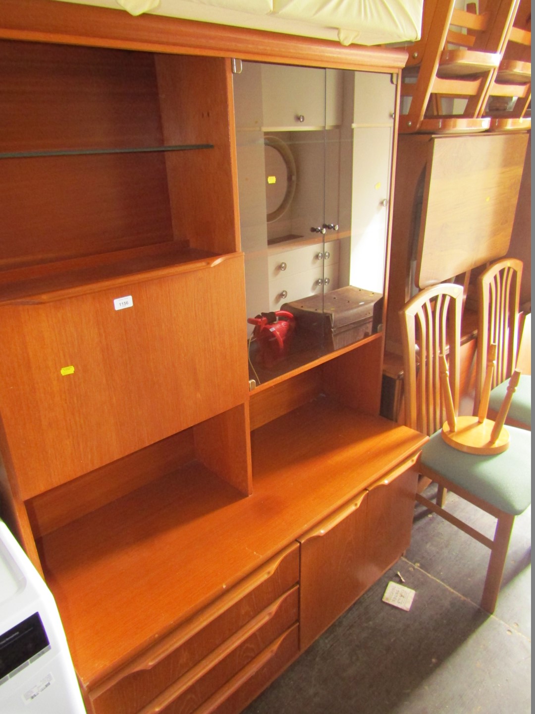 A teak finish bookcase, two sectional ottoman, two drop leaf tables, two dining chairs, and four