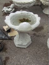 A reconstituted stone birdbath, the top shaped as a shell, on hexagonal acanthus leaf base, 50cm
