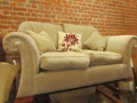 A handmade two seater sofa upholstered in cream tweed fabric.