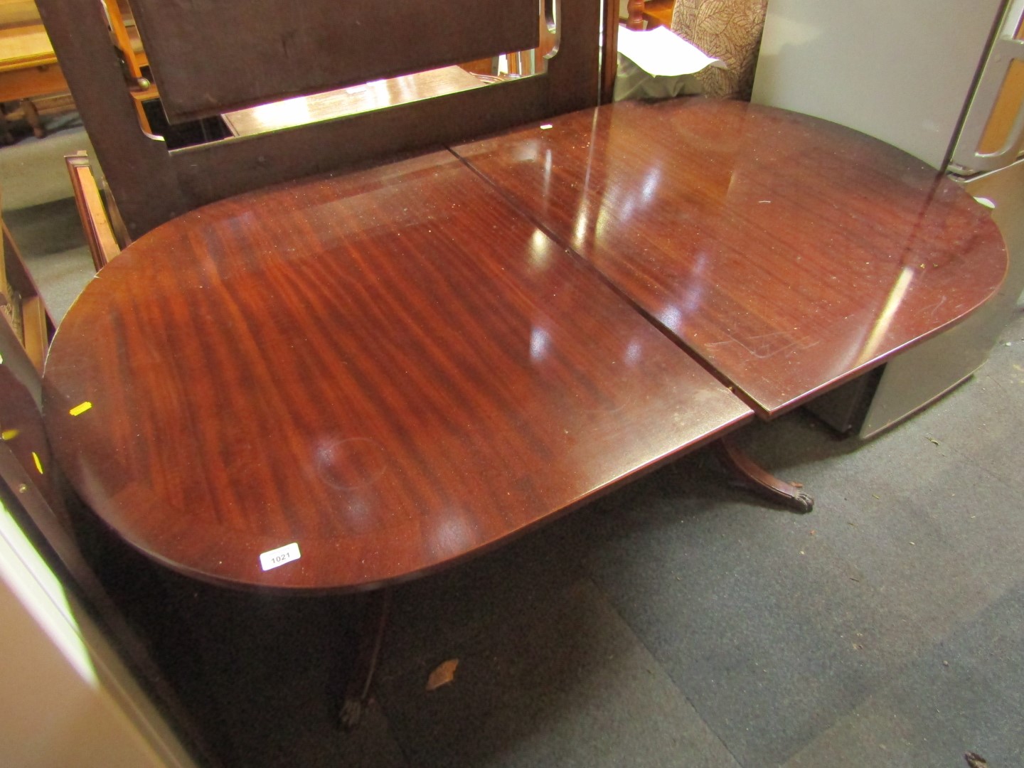 A reproduction mahogany twin pedestal extending dining table, with brass claw feet.
