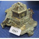 A 20thC brass inkwell, with griffin supports and ceramic insert. (AF)