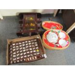 A mahogany display case, with small group of Teddies, a group of thimbles, and a wicker basket