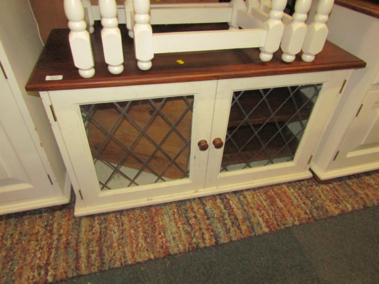 A pine and white painted low cabinet, with two astragal glazed doors.