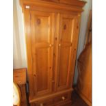 A pine double wardrobe, with moulded cornice, on drawer base.