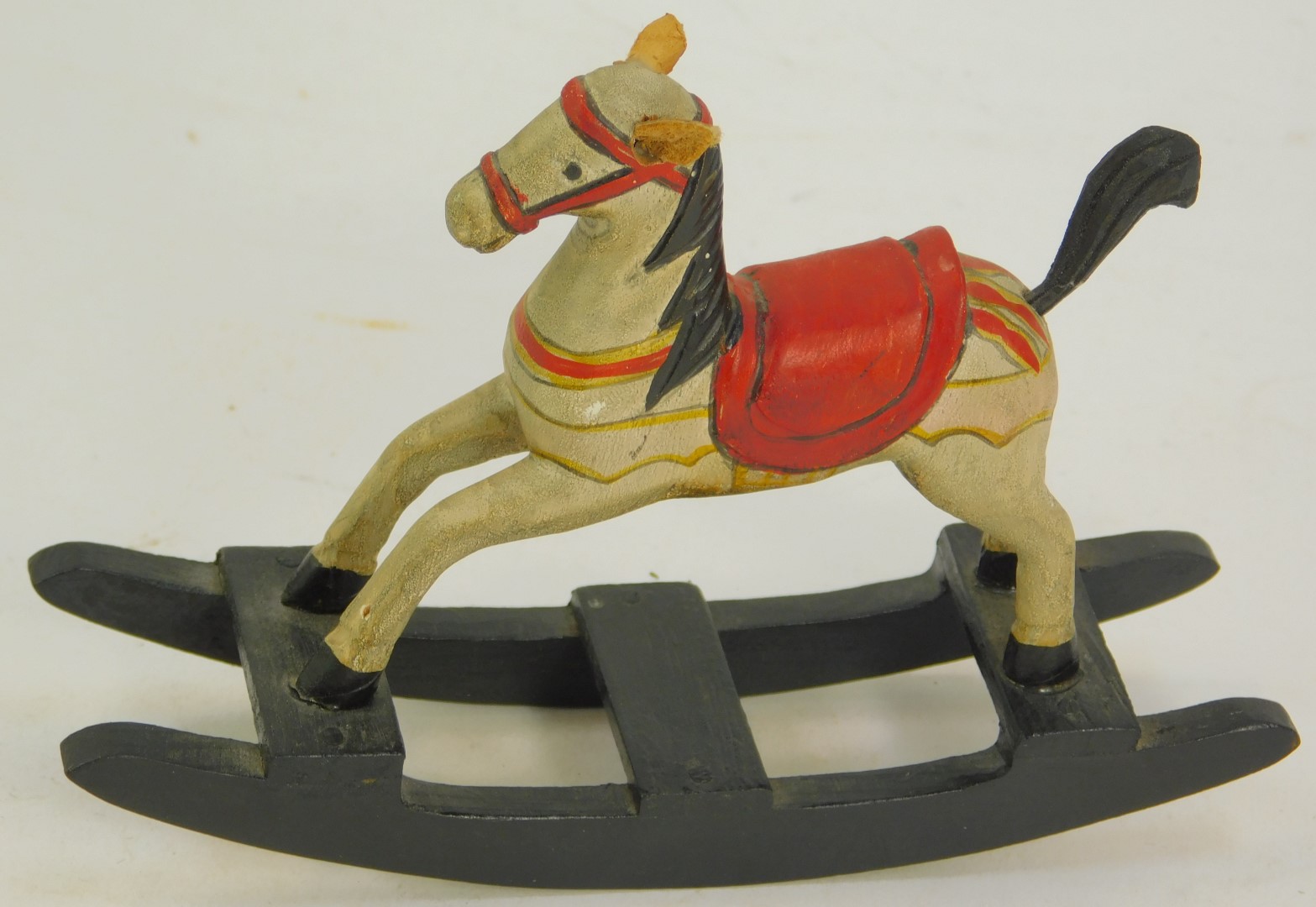 A miniature rocking horse, with red seat on painted white horse, 9cm high. - Image 2 of 3