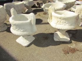 A pair of reconstituted stone garden urns, each with scroll handle, on a square foot, 53cm high,
