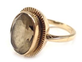 A 9ct gold dress ring, set with smoky quartz in rub over setting with star border, ring size N½, 5.1