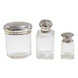 Two silver capped glass scent bottles and a toilet jar, the larger scent bottle marked Louvre Paris,