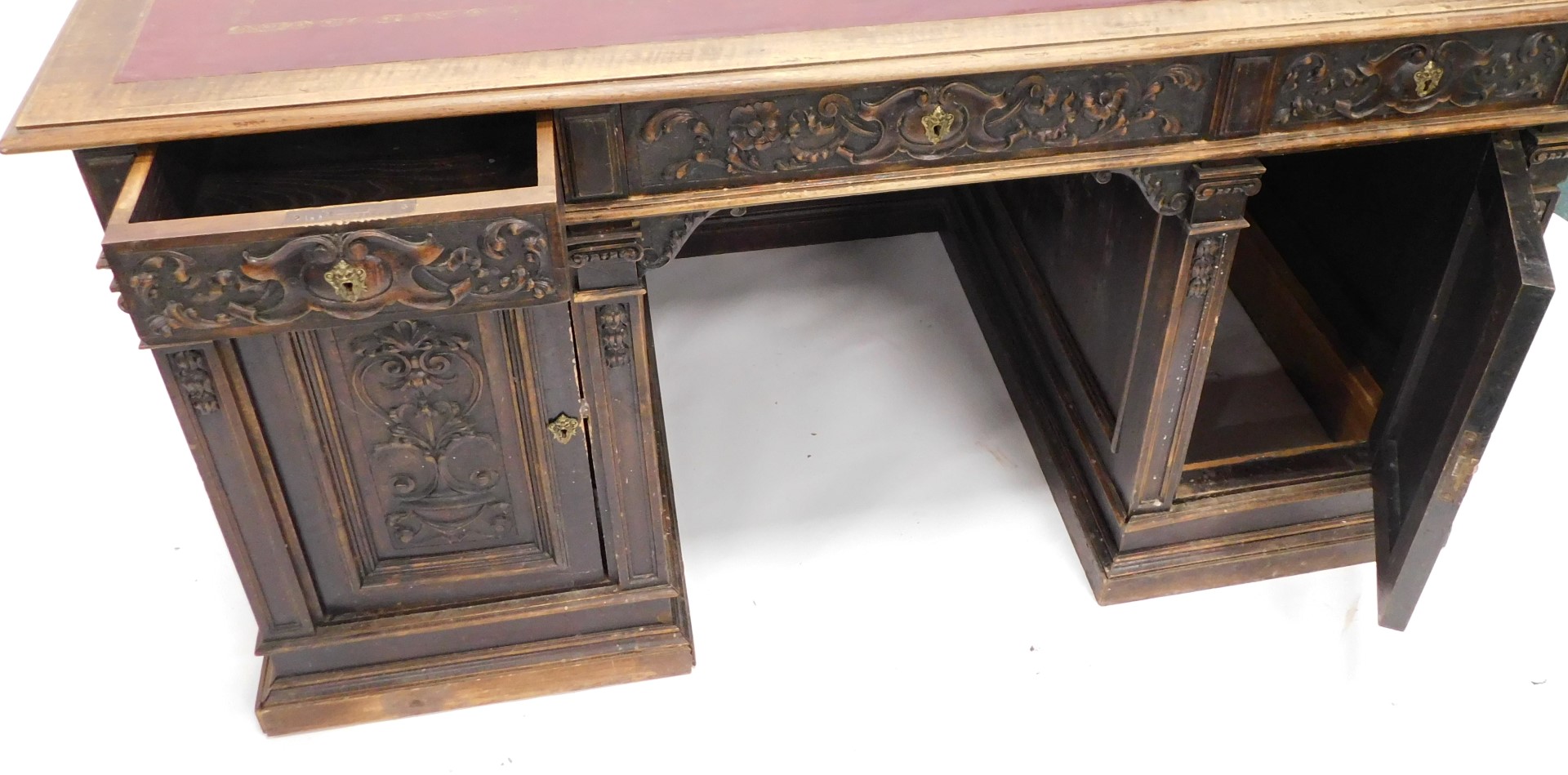 A Continental carved oak pedestal desk, the rectangular top with an ox blood red leatherette inset, - Image 5 of 6