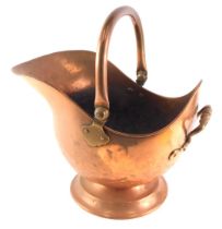 A Victorian helmet shaped copper coal scuttle, on a domed base with hinged handle.