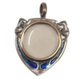 An Art Nouveau shield locket, with a brushed gold central section, in a white metal case set with bl