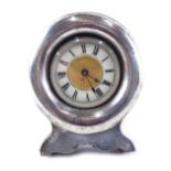 An Edwardian silver cased easel backed clock, the white enamelled dial with Roman numerals, with pla