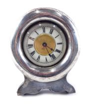 An Edwardian silver cased easel backed clock, the white enamelled dial with Roman numerals, with pla