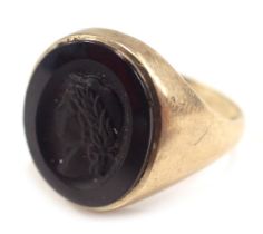 A 9ct gold signet ring, set with carved jet Grecian figure, in a rub over border, hallmarks rubbed,