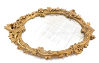 A gilt composition rococo scroll oval wall mirror, 65cm x 48cm.