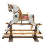 A dapple grey painted rocking horse, with part leather saddle, etc., on oak stand with turned suppor
