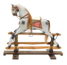 A dapple grey painted rocking horse, with part leather saddle, etc., on oak stand with turned suppor