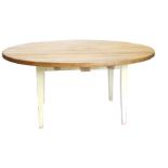A large distressed pine dining table, the circular planked top on cream painted square tapering legs
