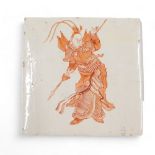 A 19thC ceramic tile, decorated with a Chinese style warrior in iron red, on a cream ground, indisti