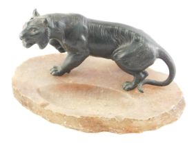 A late 19th/early 20thC Japanese green patinated spelter tiger, mounted on an alabaster ashtray, 27c