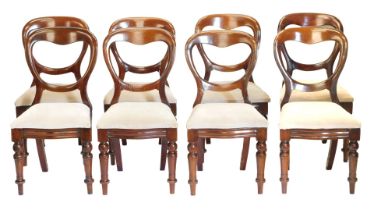 An associated set of eight Victorian mahogany balloon back chairs, each with a padded seat, on turne