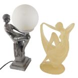 An Art Deco style silvered resin table lamp, modelled in the form of a lady holding the opaque shade