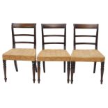 A set of three Regency mahogany dining chairs, each with a bar back, a padded seat, on turned taperi