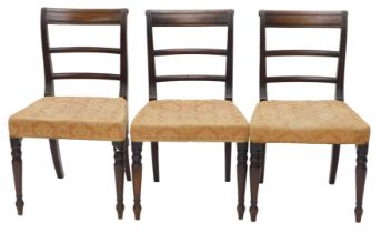 A set of three Regency mahogany dining chairs, each with a bar back, a padded seat, on turned taperi