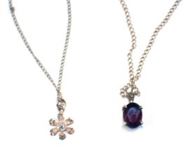 Two pendants and chains, comprising a 9ct gold fine link neck chain with a garnet set pendant, the p