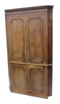 A George III mahogany standing corner cabinet, of breakfront form, with a dental cornice, above two