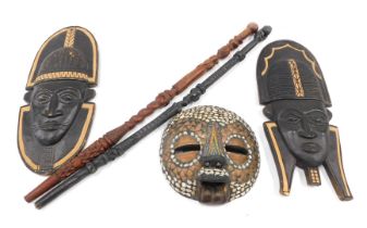 Tribal art. Two similar African tribal masks, each with ebonised detail, another mask inlaid in shel