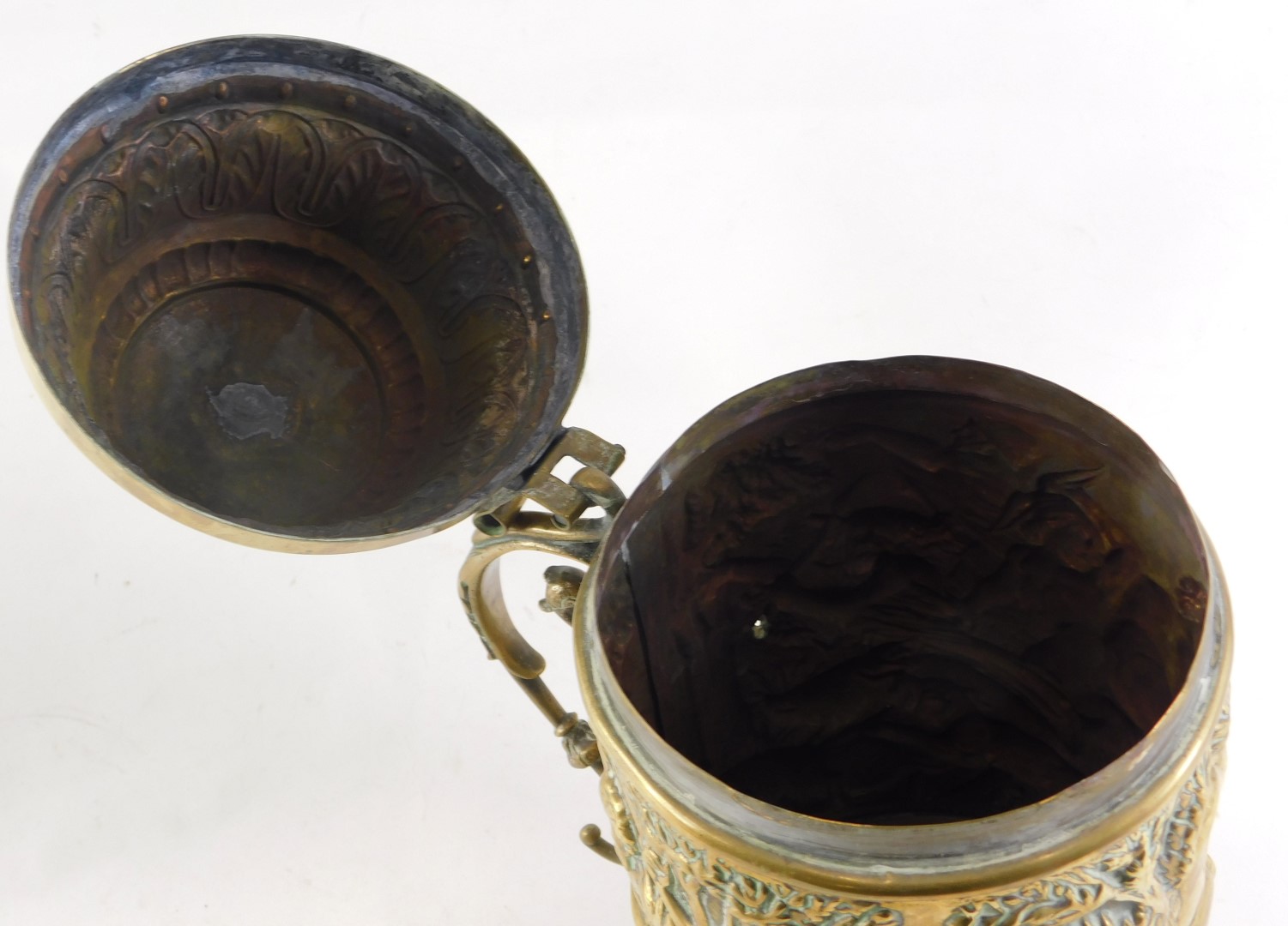 A 19thC continental embossed brass lidded tankard, decorated with figures boar hunting, and a scroll - Image 2 of 4