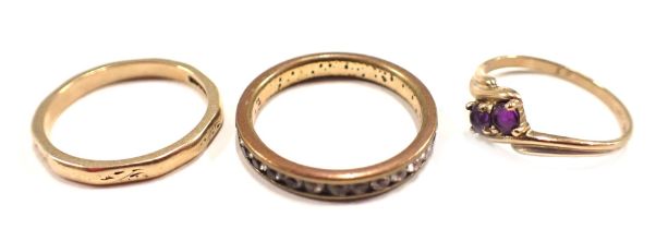 Three dress rings, comprising a 9ct gold wedding band, of hammered design, ring size K½, a 9ct gold