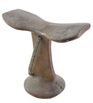 Tribal Art. An African carved wooden headrest, the domed foot with rivet repair, 21cm wide.