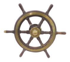 An early 20thC brass and wood ship's wheel, with turned handles, wall mount, possibly from a yacht,