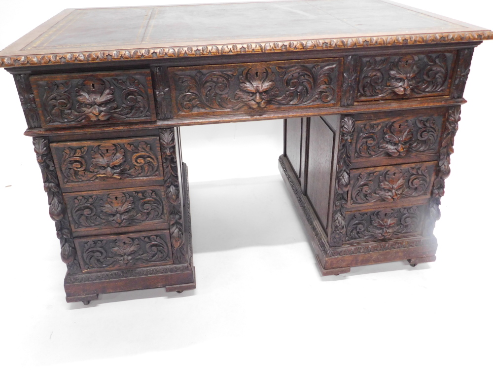 A late Victorian oak pedestal desk, carved with scrolls, leaves and masks, the rectangular top with - Image 3 of 3