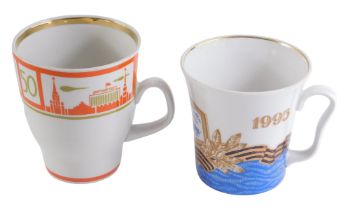 Two USSR porcelain mugs, comprising one stamped 1945-1998, 9.5cm high, and a mug with orange and gol
