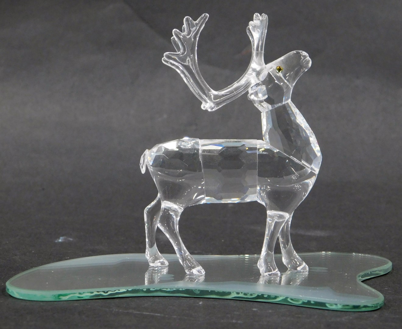 A Swarovski crystal figure of a stag, on circular base, 9cm high, boxed.