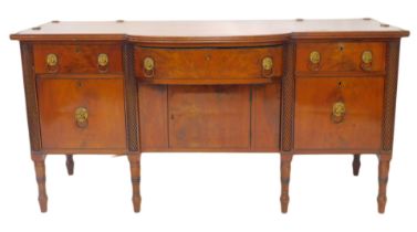 A George IV mahogany breakfront sideboard, the top with cylindrical brass rail, the base with an arr