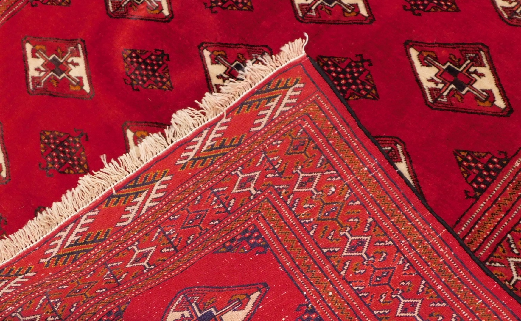 A Turkoman rug, with a design of lozenges on a red ground, 106cm x 198cm. - Image 3 of 3
