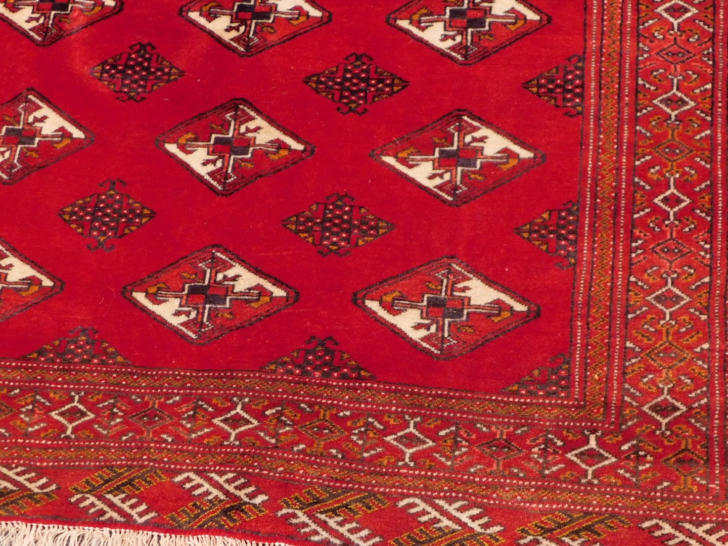 A Turkoman rug, with a design of lozenges on a red ground, 106cm x 198cm. - Image 2 of 3