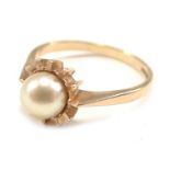 A 9ct gold dress ring, with central cultured pearl, in star setting, ring size S½, 3.3g all in.