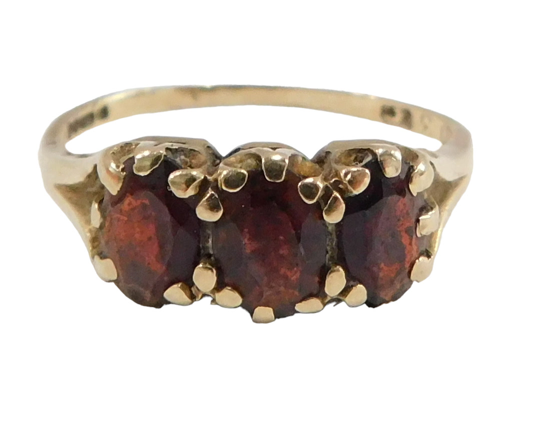 A 9ct gold garnet cluster ring, set with three oval garnets, each in claw setting, on V splayed shou