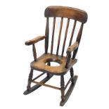 An ash and beech child's Windsor rocking armchair, with spindled turned back, recess to the solid se