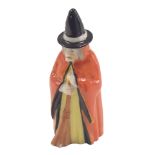 A Royal Worcester candle snuffer, modelled as a witch in red overcoat, 10cm high.