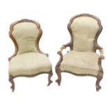 A Victorian walnut show frame armchair, with a padded back and seat, on cabriole legs with ceramic c