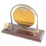 A brass gong, engraved with a ship, on a rectangular base, 27cm wide.