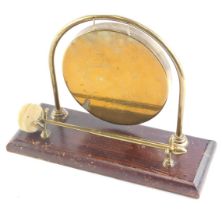 A brass gong, engraved with a ship, on a rectangular base, 27cm wide.