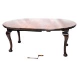 An early 20thC walnut extending dining table, the oval top with a moulded edge on cabriole legs with