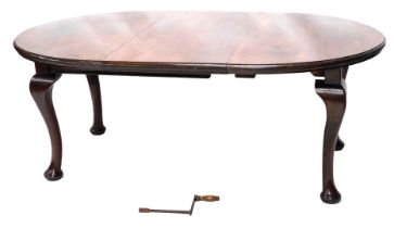 An early 20thC walnut extending dining table, the oval top with a moulded edge on cabriole legs with